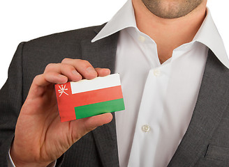 Image showing Businessman is holding a business card, Oman