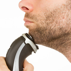 Image showing Young man shaving his beard off