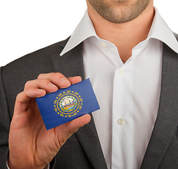 Image showing Businessman is holding a business card, New Hampshire