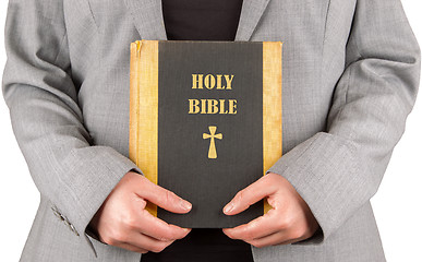 Image showing Woman in business suit is holding a holy bible