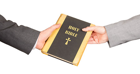 Image showing Man and woman in business suits are holding a holy bible