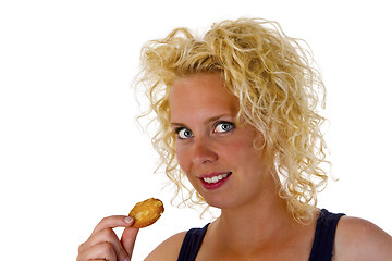 Image showing Young woman eating cookie