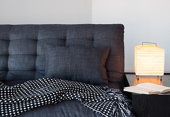 Image showing Cozy gray sofa, table lamp and book