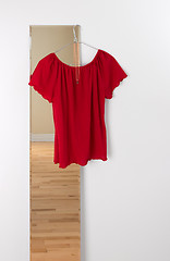 Image showing Red blouse hanging on a mirror