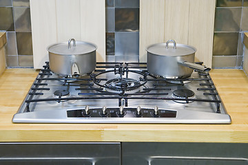 Image showing Two saucepans on a gas hob