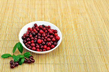 Image showing Lingonberry in a white cup on a bamboo mat