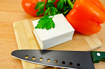 Image showing Feta cheese on a board with a knife and vegetables