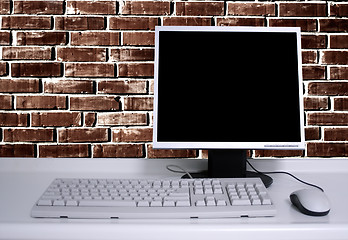 Image showing PC with black desktop and brick wall background