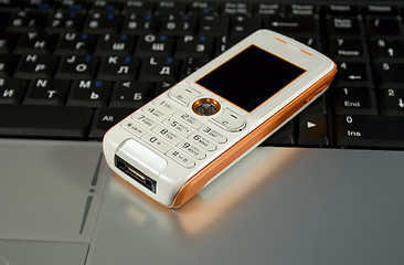 Image showing Mobile phone on a laptop