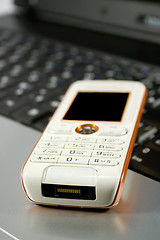 Image showing Mobile phone on a laptop