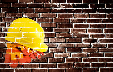 Image showing Yellow hard hat and protective gloves with grunge wall backgroun