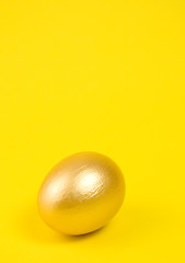 Image showing Golden egg on yellow background. Lots of space for text