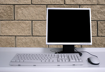 Image showing PC with black desktop and brick wall background