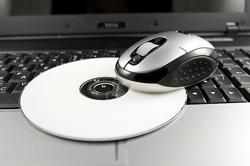 Image showing Mouse with white CD on a laptop keyboard