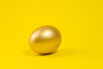 Image showing Golden egg on yellow background. Lots of space for text
