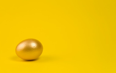 Image showing Golden egg on yellow background. Lots of space for text