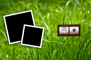 Image showing Energy outlet in grass with empty frames.Environment concept.