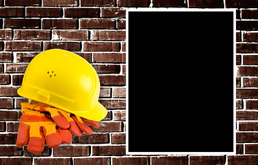 Image showing Yellow hard hat and protective gloves with grunge wall backgroun