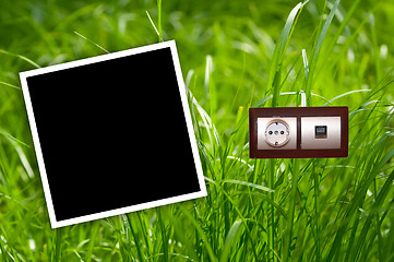 Image showing Energy outlet in grass with empty frames.Environment concept.