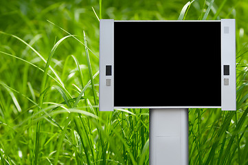 Image showing Blank advertising billboard with green grass background
