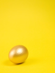 Image showing Golden egg on yellow background. Lots of space for text