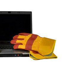 Image showing Protective gloves on a laptop isolated. Empty black desktop for 