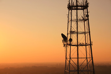 Image showing Communication tower at sunset with cityscape