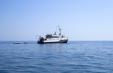 Image showing Ship and several boats going into the sea.