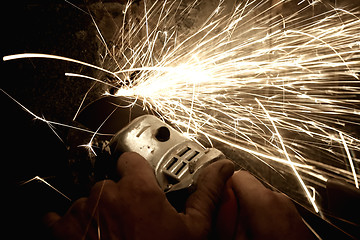 Image showing Sparks from a worker grinding steel
