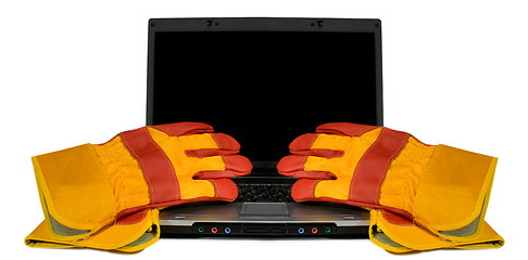 Image showing Protective gloves on a laptop isolated. Empty black desktop for 