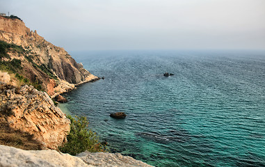 Image showing Sea with rocky beach at sunset