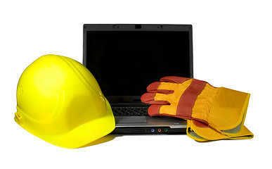 Image showing Yellow Hard Hat and protective gloves on a laptop isolated.Empty