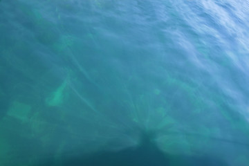 Image showing Rays of light falling into the sea.Close up to the waves surface