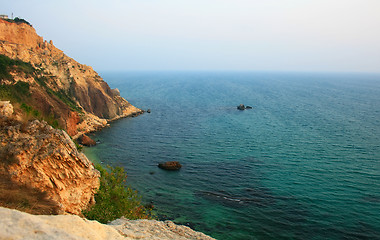 Image showing Sea with rocky beach at sunset