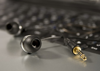 Image showing Modern Headphones on a laptop keyboard