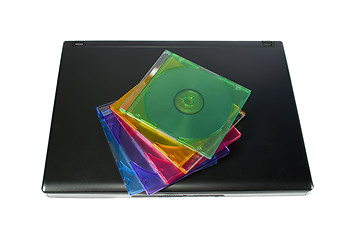 Image showing Colored cd`s on a laptop isolated