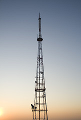 Image showing communication tower at sunset with cityscape