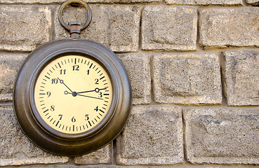 Image showing Old street clock on a stone wall