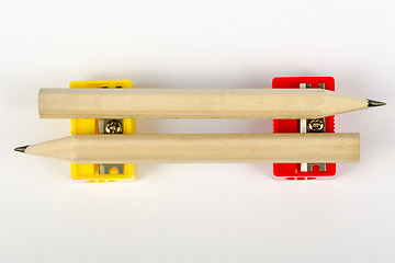 Image showing Two wooden pencils with red and yellow pencil sharpeners