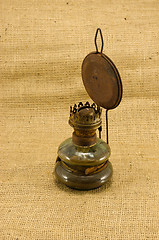 Image showing rusty retro paraffin lamp burlap background 