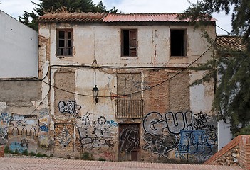 Image showing Facade of a deserted house with bricked-up windows and graffiti