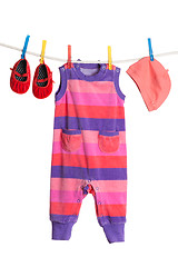 Image showing A set of children's clothes hanging on a clothesline.