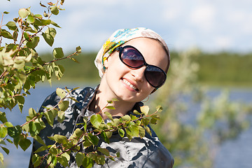 Image showing Portrait of a blond girl behind the green bush