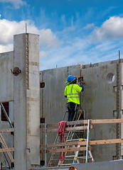 Image showing Working in a green jacket at a construction site