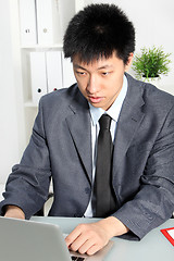 Image showing Professional Asian man focusing at his desk