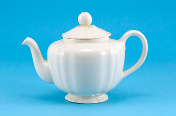 Image showing retro ceramic white teapot dish on blue background 