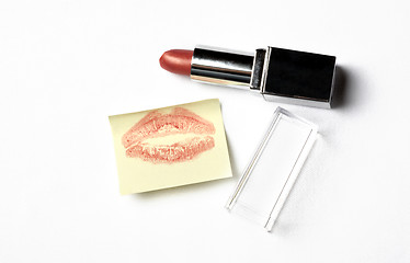 Image showing red lipstick and yellow sticker note with kiss