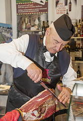 Image showing Man cutting a ham 