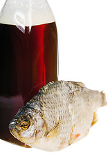 Image showing A bottle of domestic beer and dried fish is isolated on white 