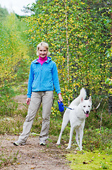 Image showing The woman with a dog walk in an autumn wood